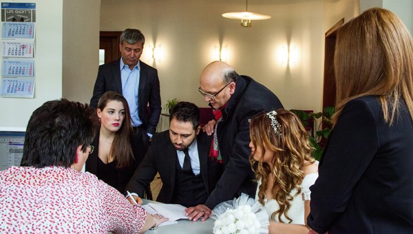 Ahlam Shibli, Ahlam Shibli, Untitled (Heimatno. 27), Nordhessen, Germany, 2016–17.
Rathaus Kassel, March 3, 2017. Murat Çakır’s presence as a translator is required at the wedding of Çiğdem Yalcin and Göksel Akgül at Kassel City Hall because the groom, originating from Izmir in Turkey, doesn’t speak German. The young people met during the bride’s vacation in Turkey and decided to establish themselves at the center of her life. Mr. Akgül will work in Kassel at the bride’s father’s advertising agency. Mr. Çakır considers this photograph of the wedding ceremony important because the presence of the translator demonstrates that Germany is, and has been for long a time despite all political denial, a country of immigrants. The bride’s father is called Hüseyin Yalcin and belongs to the second generation of guest workers. The witnesses are Jessica Seitz and Senem Korkmaz
© and courtesy the artist