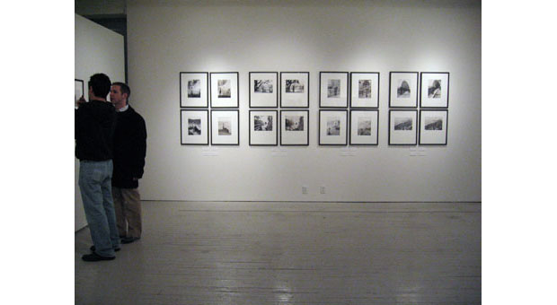 Two people view Landscapes without Memory photographs by Joan Fontcuberta and Parallel Memories photographs by Bruno Rosier on view at Aperture Gallery