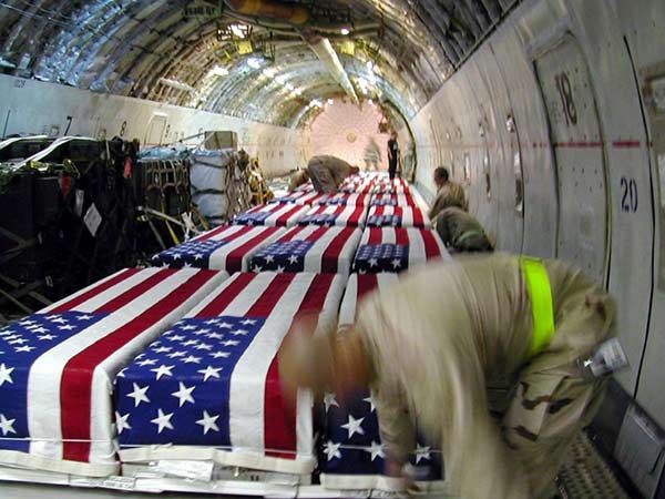 The coffins of American service members killed in Iraq sit aboard a cargo plane waiting to be sent back to the United States. Kuwait City, Kuwait, 2004. Courtesy Tami Silicio/Zuma Press