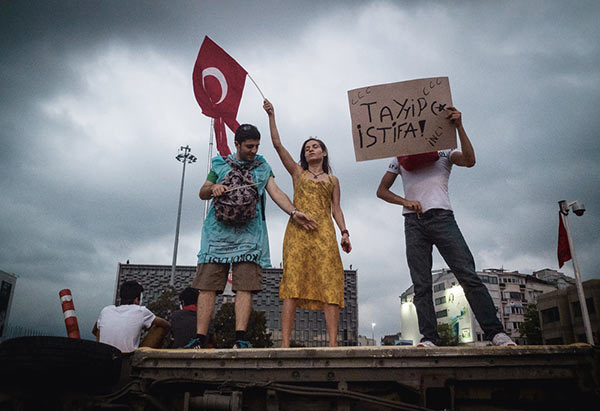 Mehmet Kacmaz, Protesters holding a sign calling for the resignation of Turkish Prime Minister Recep Tayyip Erdoğan during protests in Gezi Park, Istanbul, June 2, 2013 © the artist/NAR and courtesy Redux Pictures