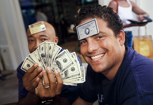 Lauren Greenfield, Film director and producer Brett Ratner, 29, and Russell Simmons, 41, a businessman and cofounder of hip-hop label Def Jam, at L’Iguane restaurant, St. Barts. Few establishments on the island accepted credit cards, and visitors often carried large amounts of cash, 1998 © the artist and courtesy the Annenberg Space for Photography 