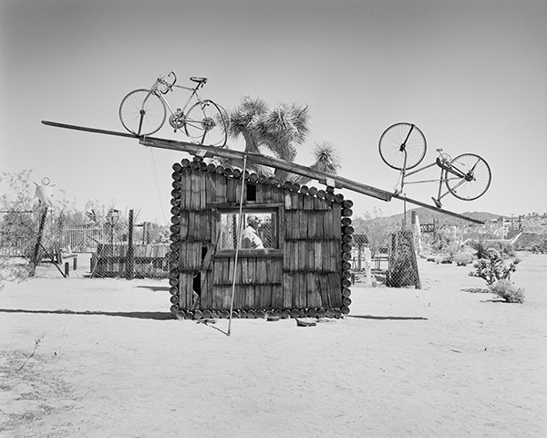 LaToya Ruby Frazier, Pat Brunty, the caretaker, standing behind No Contest (1994). Noah Purifoy Outdoor Desert Art Museum, Joshua Tree, California, 2016 © the artist 