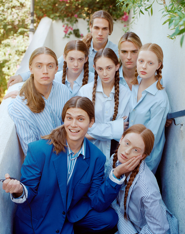 Color photograph of a group of people with long hair and blue shirts