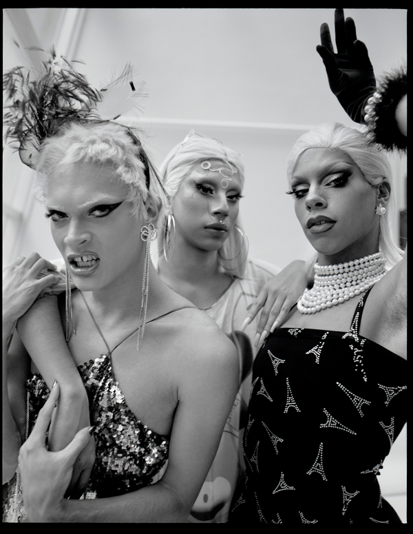 Black-and-white photograph of three subjects with blond wigs