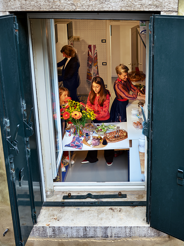 A family prepares dinner in a kitchen. Gail Albert Halaban