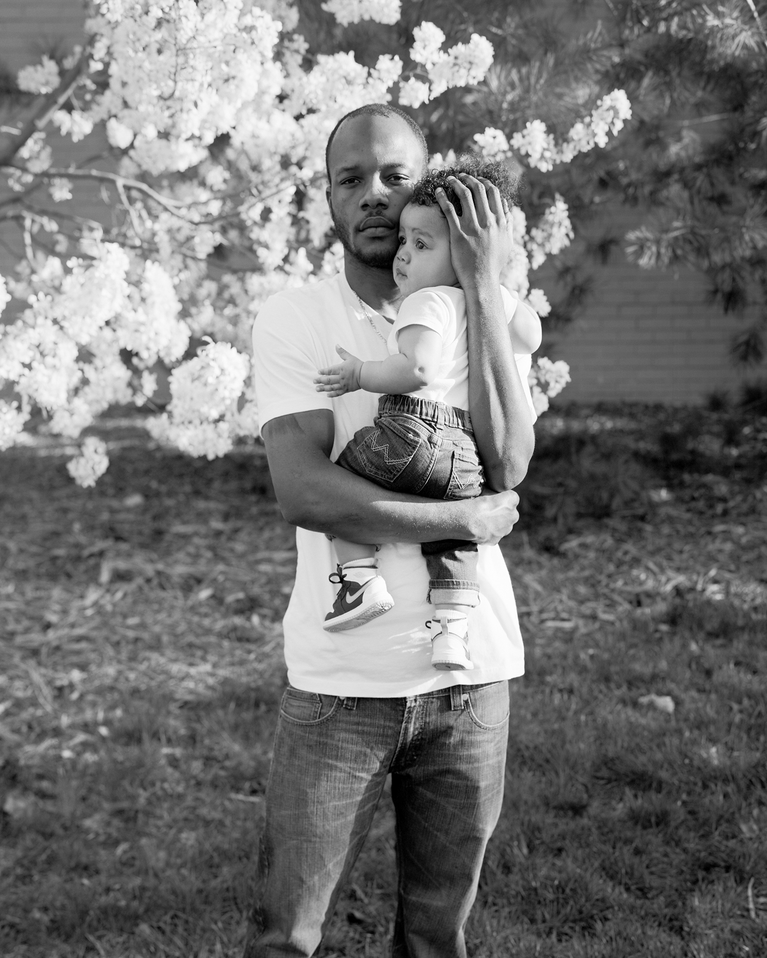 Zora Murff, black and white portrait of man holding child