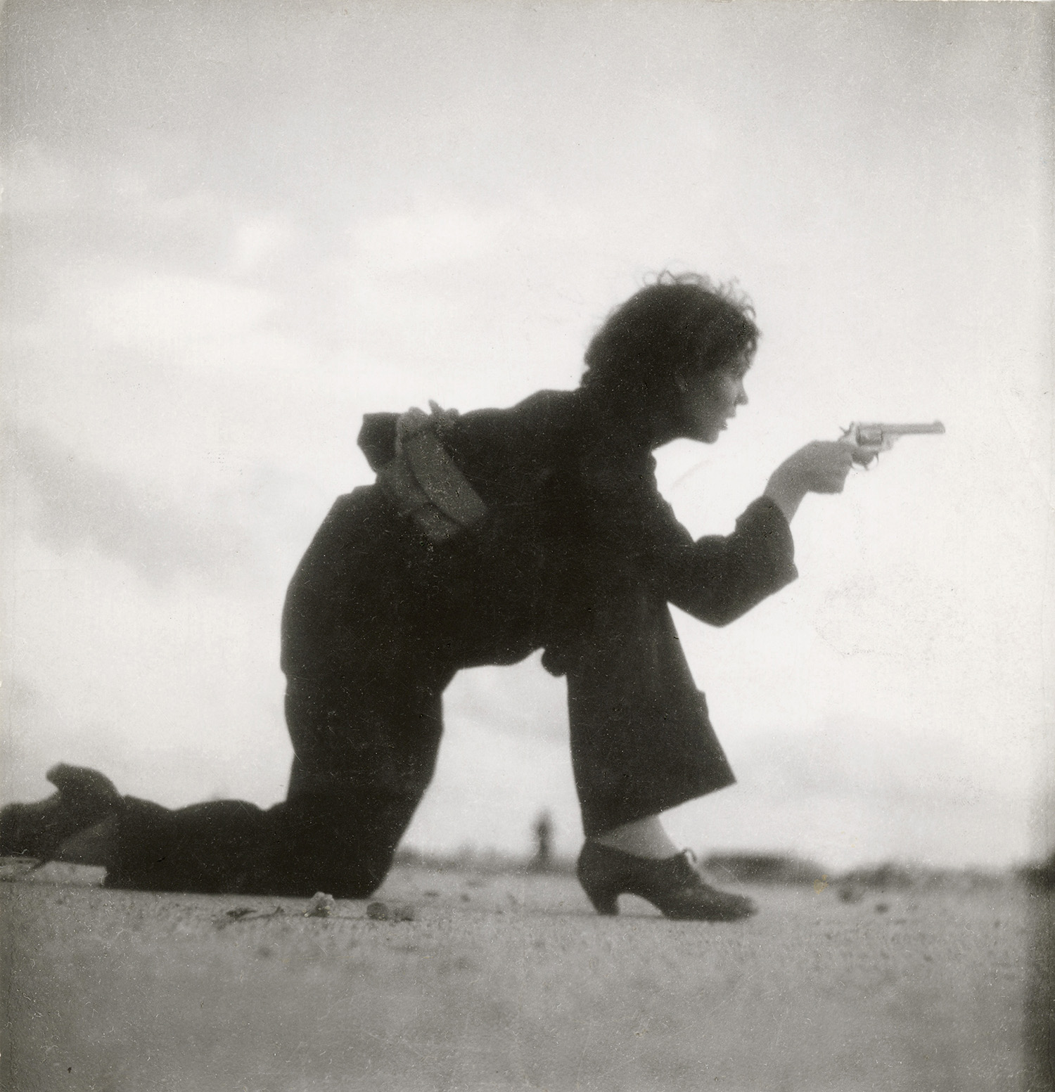 profile of woman kneeling with pistol in hand