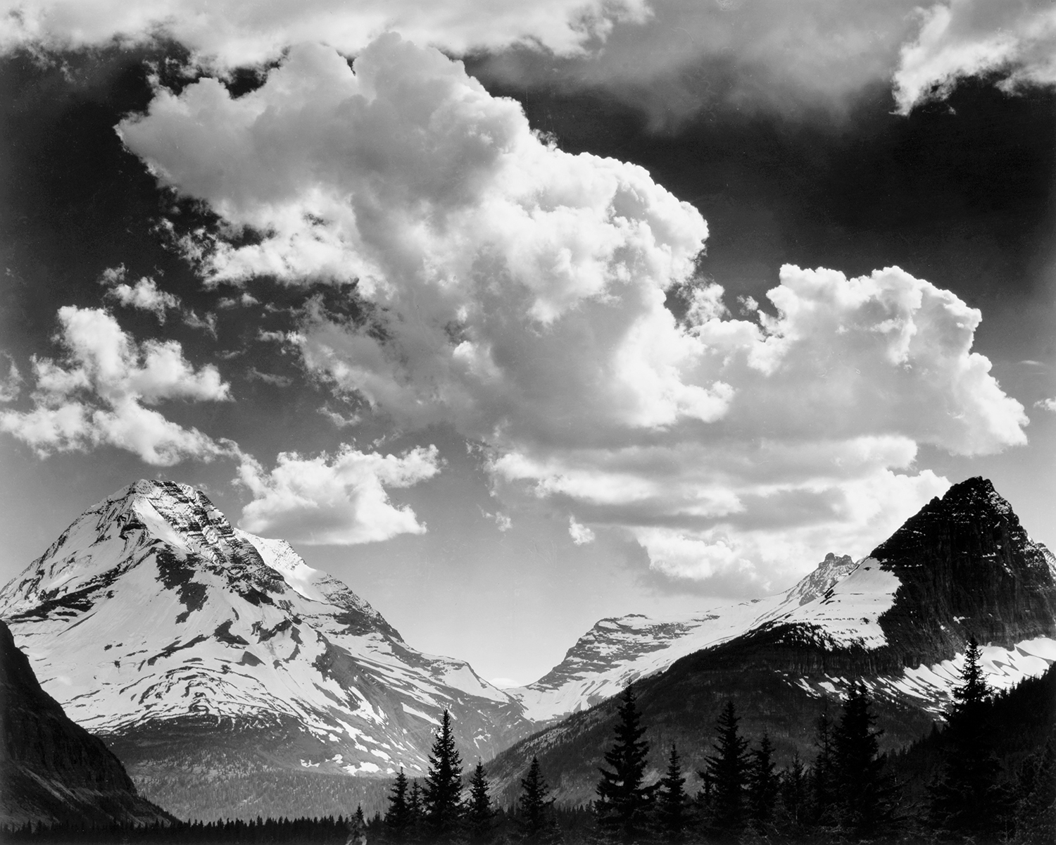 black and white landscape of snow-capped mountains and clouds