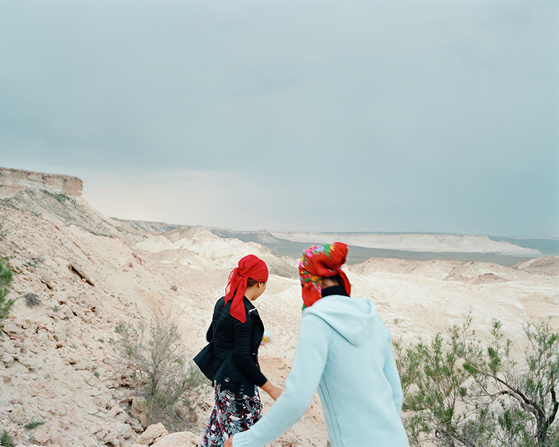 Chloe Dewe Mathews, Two sisters run down to the remote underground mosque at Beket-Ata. They traveled six hours from Aktau, accompanying their family on a

pilgrimage to pray for their uncle’s recovery. Mangystau Region, Kazakhstan, 2010; from Chloe Dewe Mathews: Caspian: The Elements (Aperture and Peabody Museum Press, 2018)