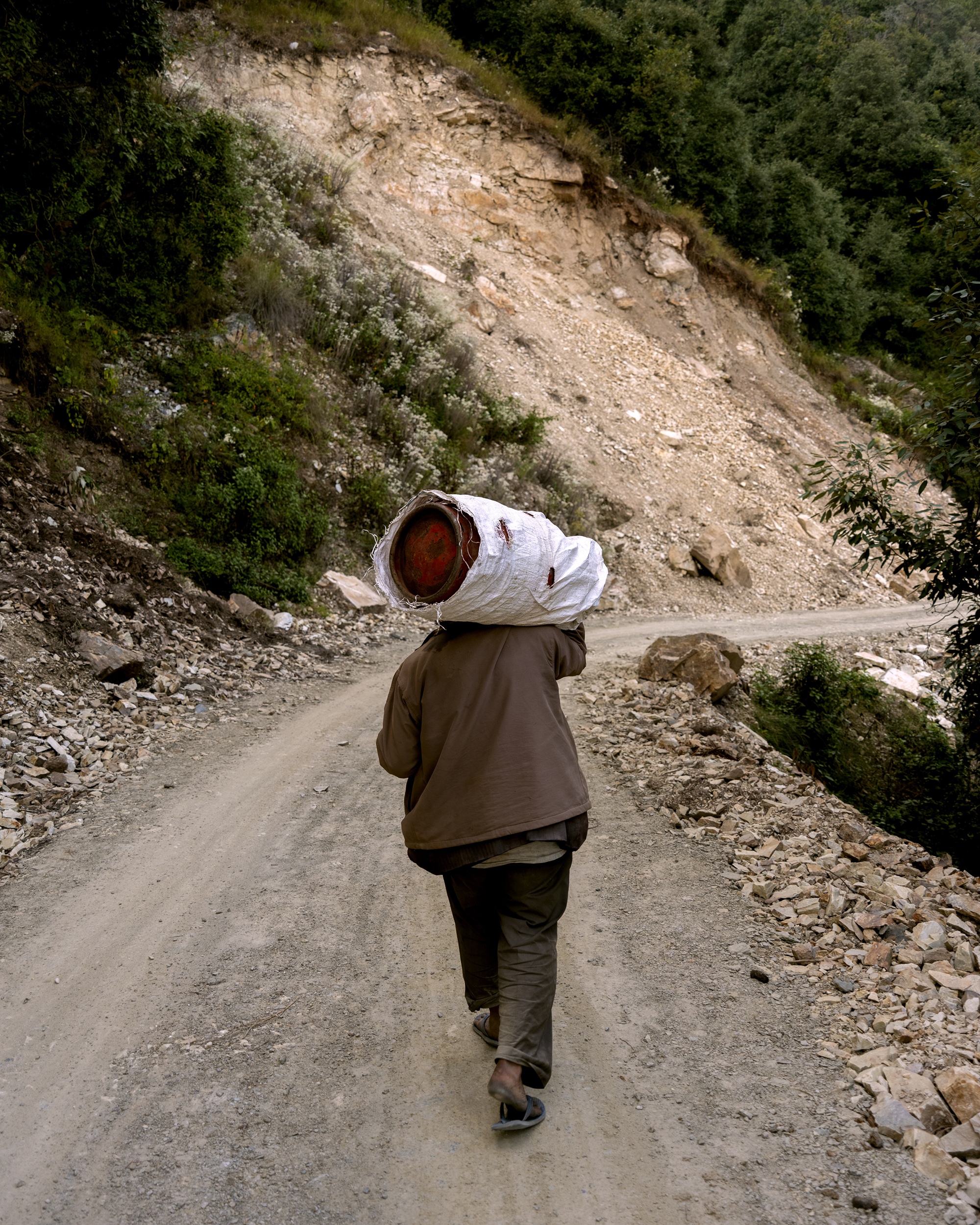 Ashish Shah, <em>A man walking to Baluni Village with a gas cylinder</em>, 2022″>
		</div>
		<div class=