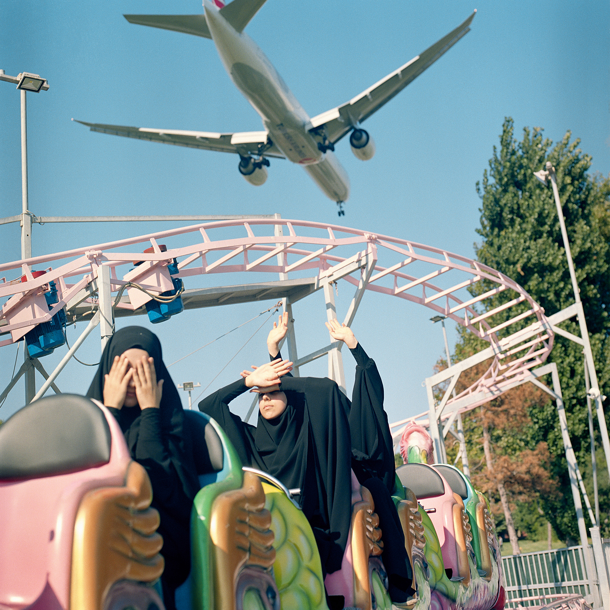 Sabiha Çimen, <em>A plane flies low over students at an amusement park, Istanbul</em>, 2018, from <em>HAFIZ</em>“>
		</div>
		<div class=