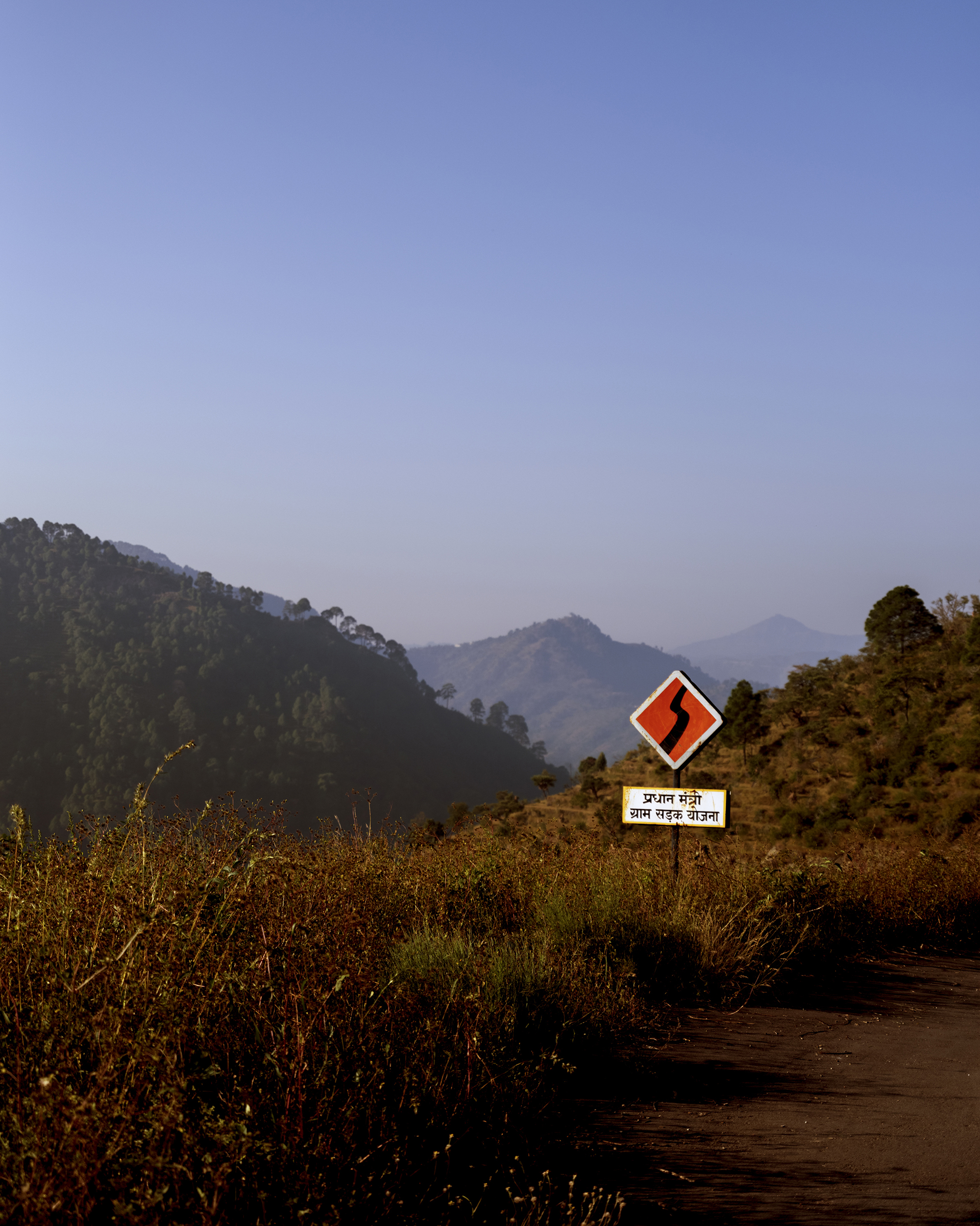 Ashish Shah, <em>Signage of the Prime Minister Road planning on the way to Kothar</em>, 2022″>
		</div>
		<div class=