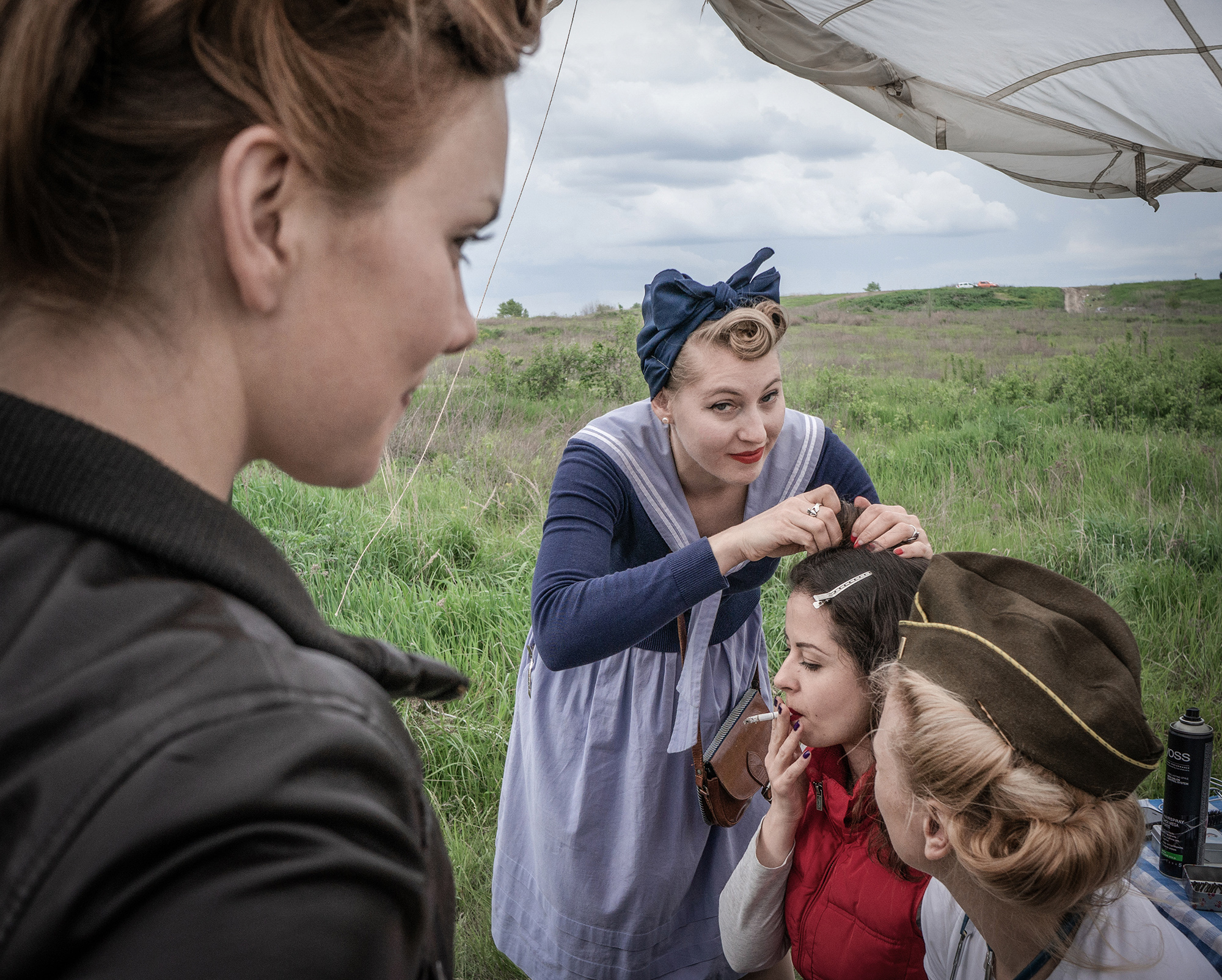 May 2016 , Kyiv
Nika Chik (Vintage stylist and blogger ) making vintage hairdos during WorldWarII  reconstruction on Kyiv  outskirts to Mark the end of war in Europe and on the day Europe does 8th of May not Soviet 9th of May . Although at the time both days were still holidays , 8th of May celebrations was introduced as part od moving away from Communist, Soviet past )