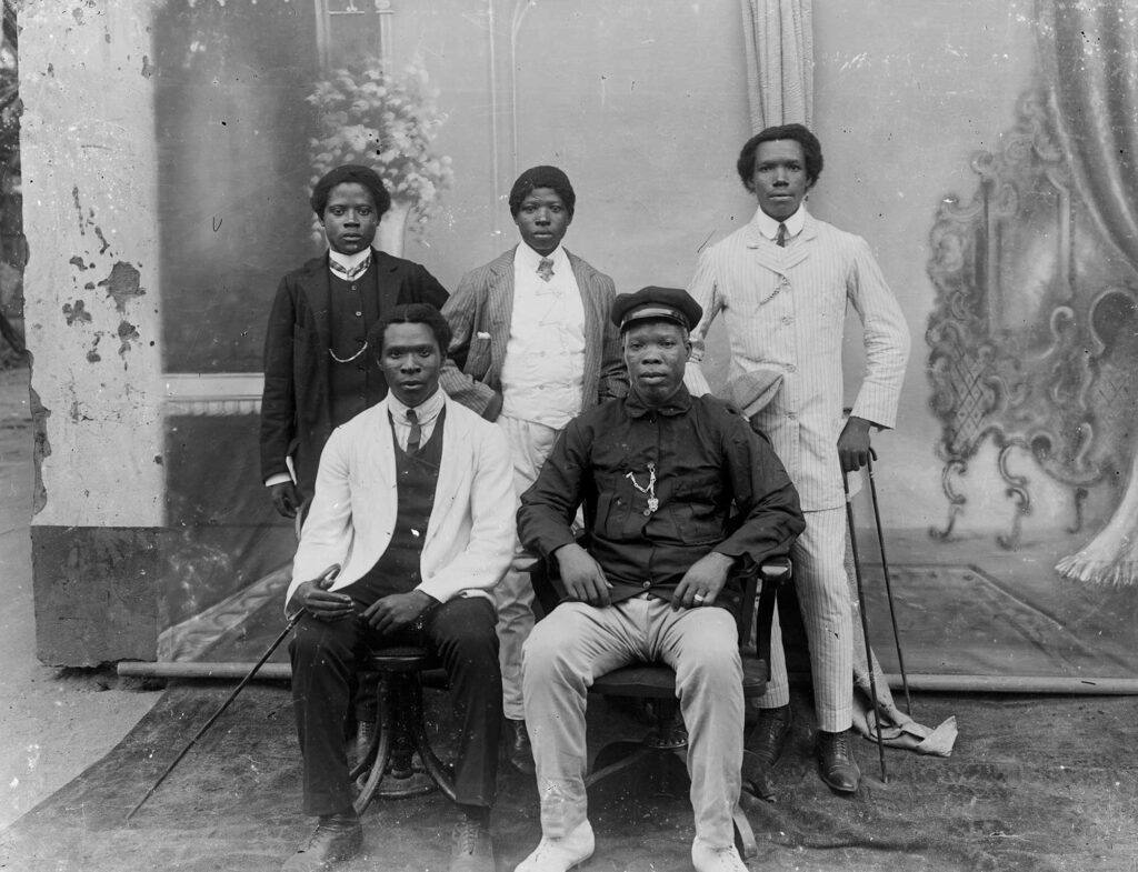 Black and white photograph of 5 Black men in suits