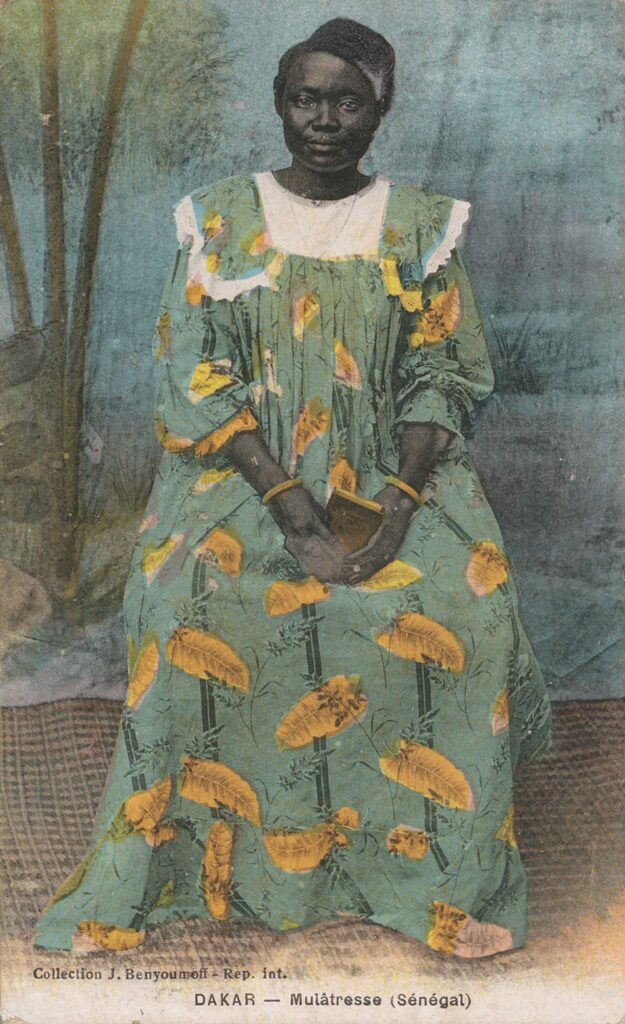 Colorized postcard portrait of a Senegalese woman in a patterned dress