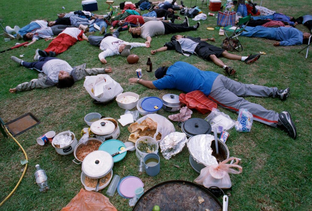 A color photograph of a group of people lying on the grass