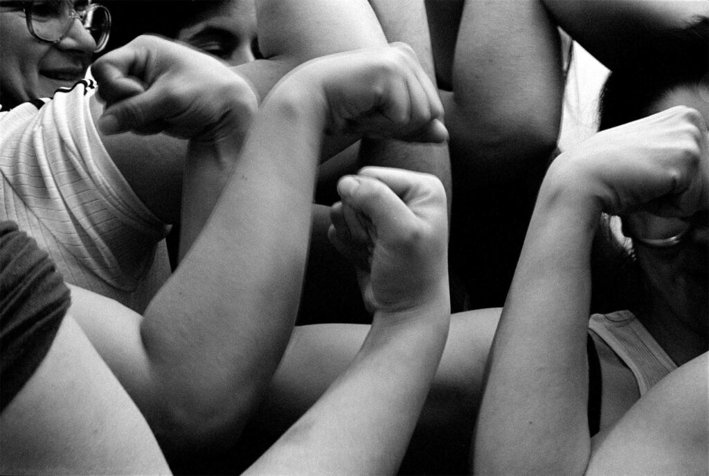 A black-and-white photograph of figures flexing their arm muscles.