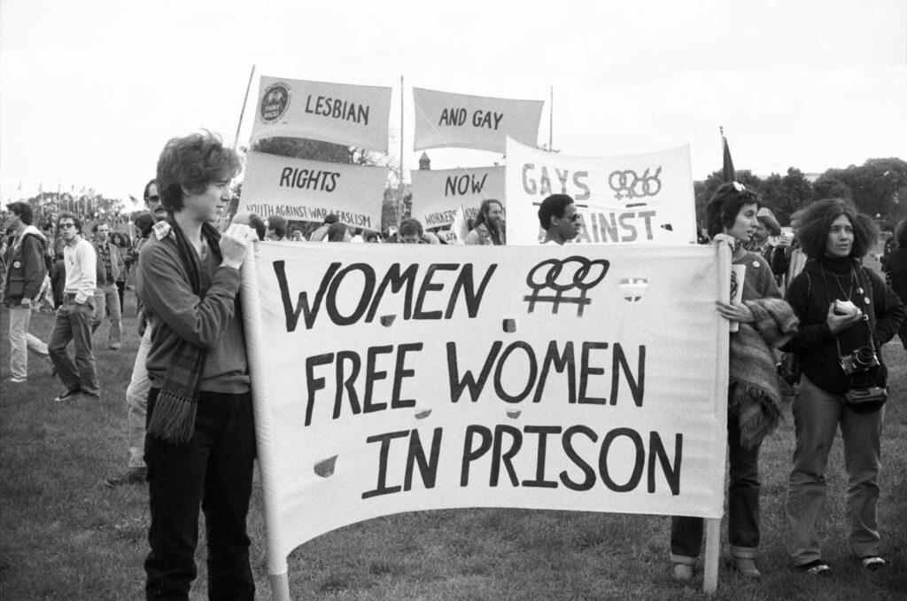 A black-and-white photograph of women holding signs at a lesbian rights protest