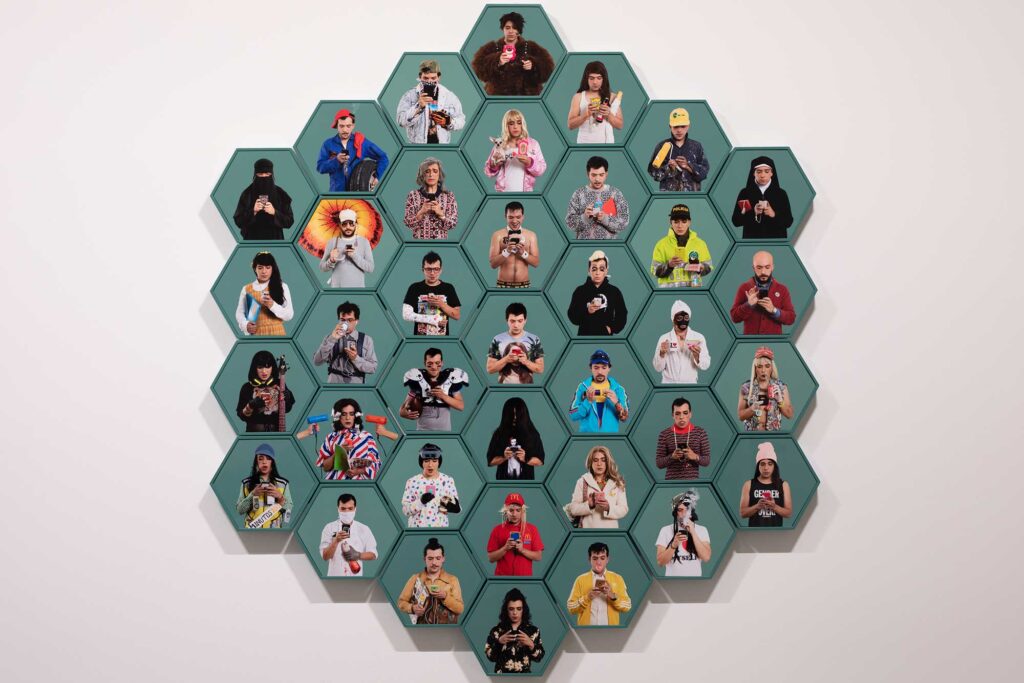 37 self-portraits by the artist in various guises mounted to hexagonal green wood frames