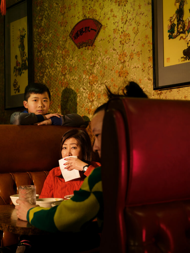 A family enjoying a meal together in a restaurant booth.