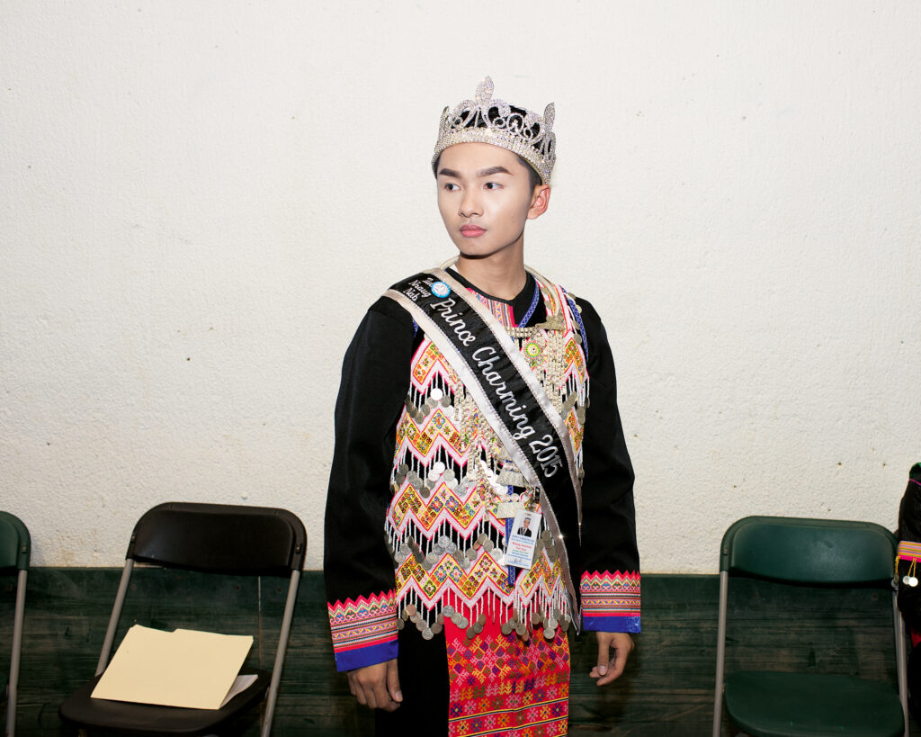 A young boy wearing a crown and a sash that reads "Prince Charming 2015."