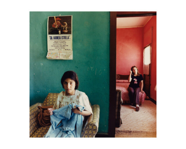 A young girl and young women sit in two rooms, one green, one red.