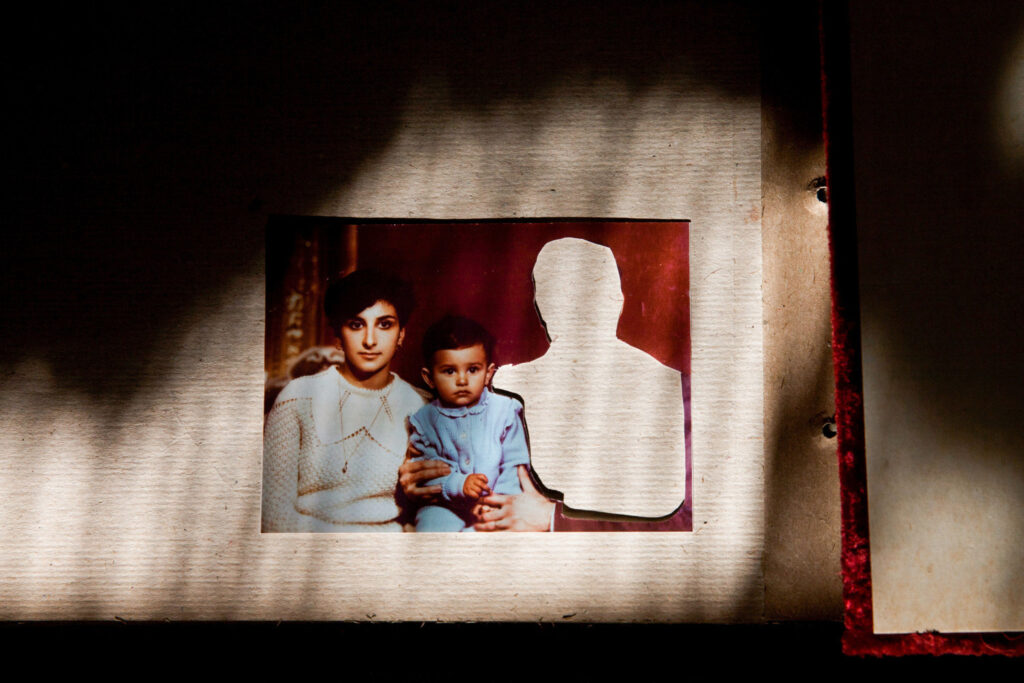 A photograph of three individuals sits on a table. One figure is cut out.