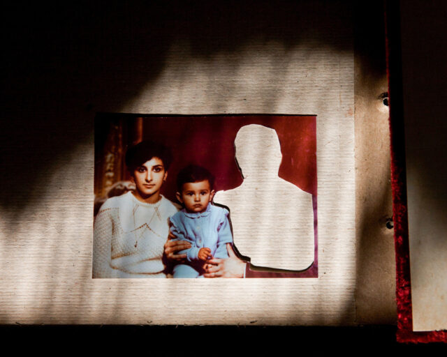 A photograph of three individuals sits on a table. One figure is cut out.