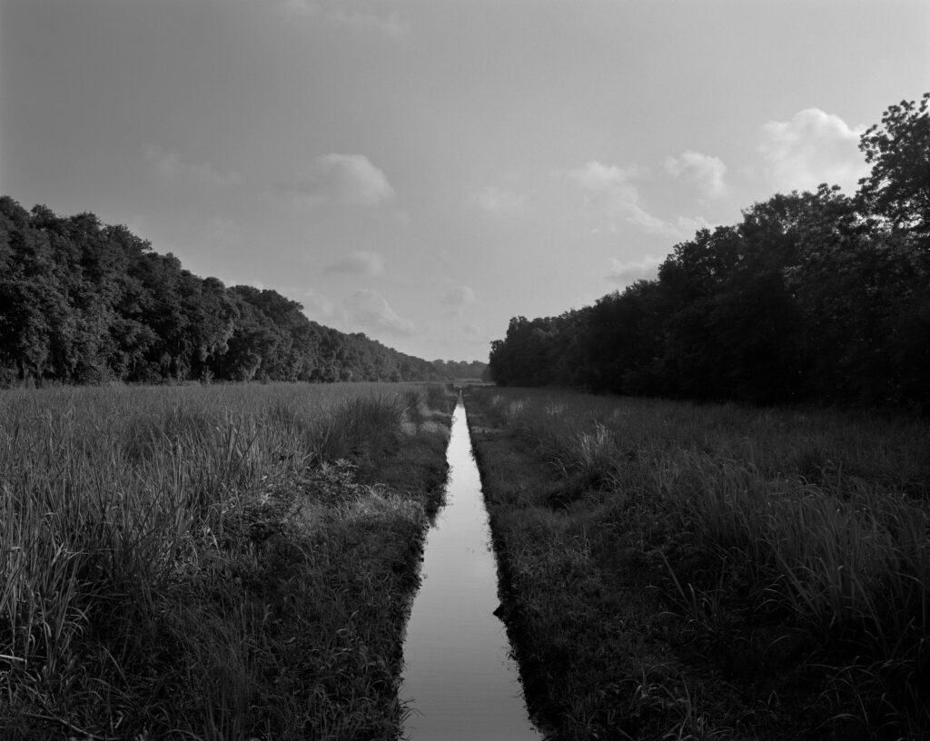 An irrigation ditch bisects a landscape.