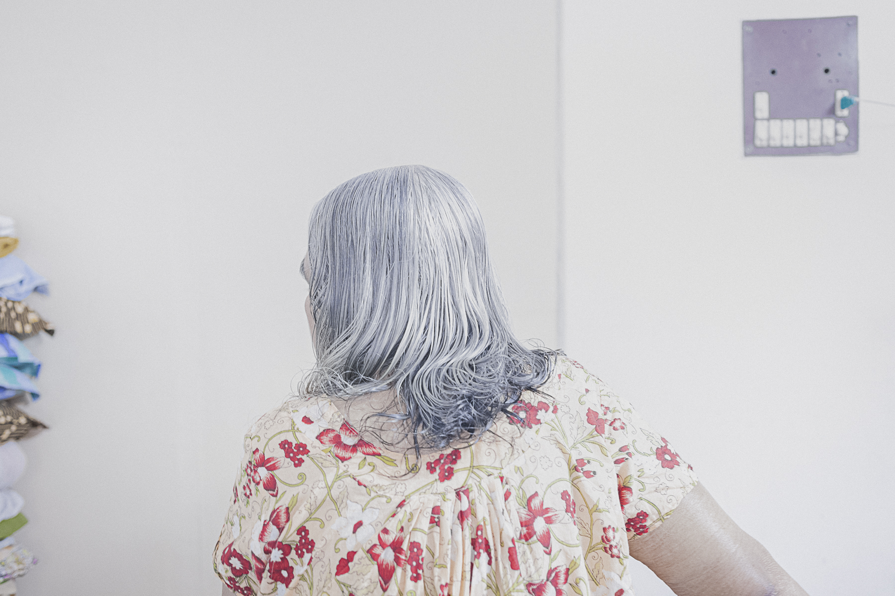It was in the afternoon.I was sitting on my grandpa’s couch. The door was slightly open and I saw light coming through, washed out between the white door and white walls. All of a sudden it all started making sense. I could relate what I was seeing with what I felt.
John and Prova, my grandparents. While growing up, I found much love and care from them. They were young and strong. As time went by it shaped everything in it’s own way. Bodies took different forms and relations went distant. Grandma’s hair turned gray, the walls started peeling off and the objects were all that remained. Everything was contained into one single room.
They always loved the fact that I take pictures of them, because then I spend more time with them and they don’t feel lonely anymore. After Prova passed away, I try to visit more so John can talk. He tells me stories of their early life, and how they met. There are so many stories. Here, life is silent, suspended. Everything is on a wait. A wait for something that I don’t completely understan
