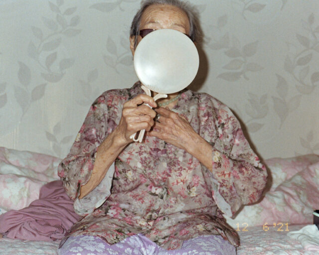 An older person looks in a mirror