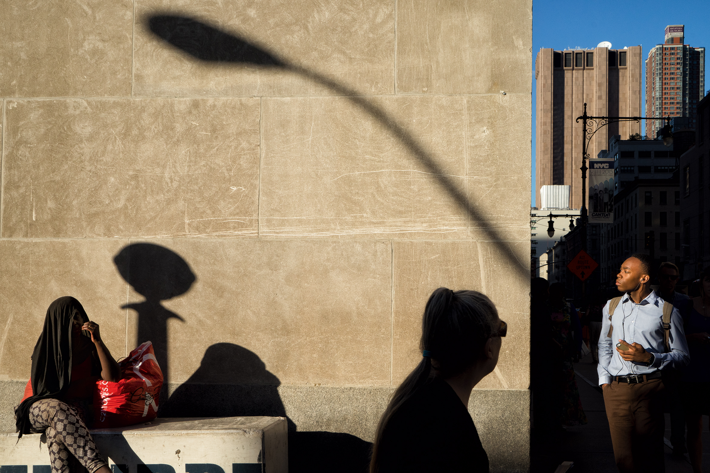 Shadows people on a wall on a city street.
