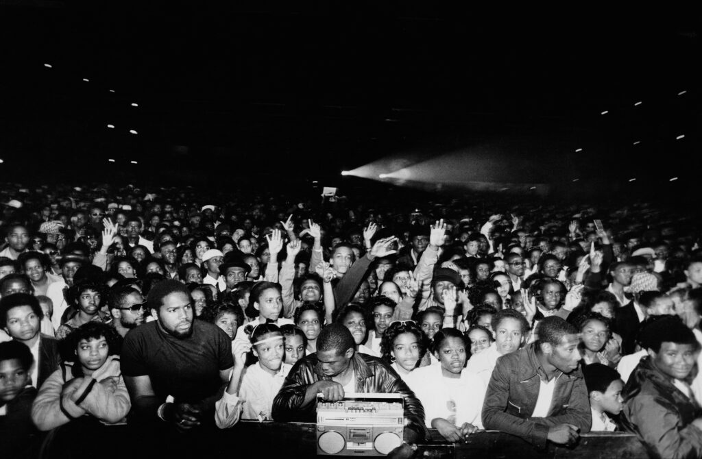 A large crowd of people pressed up against a stage.