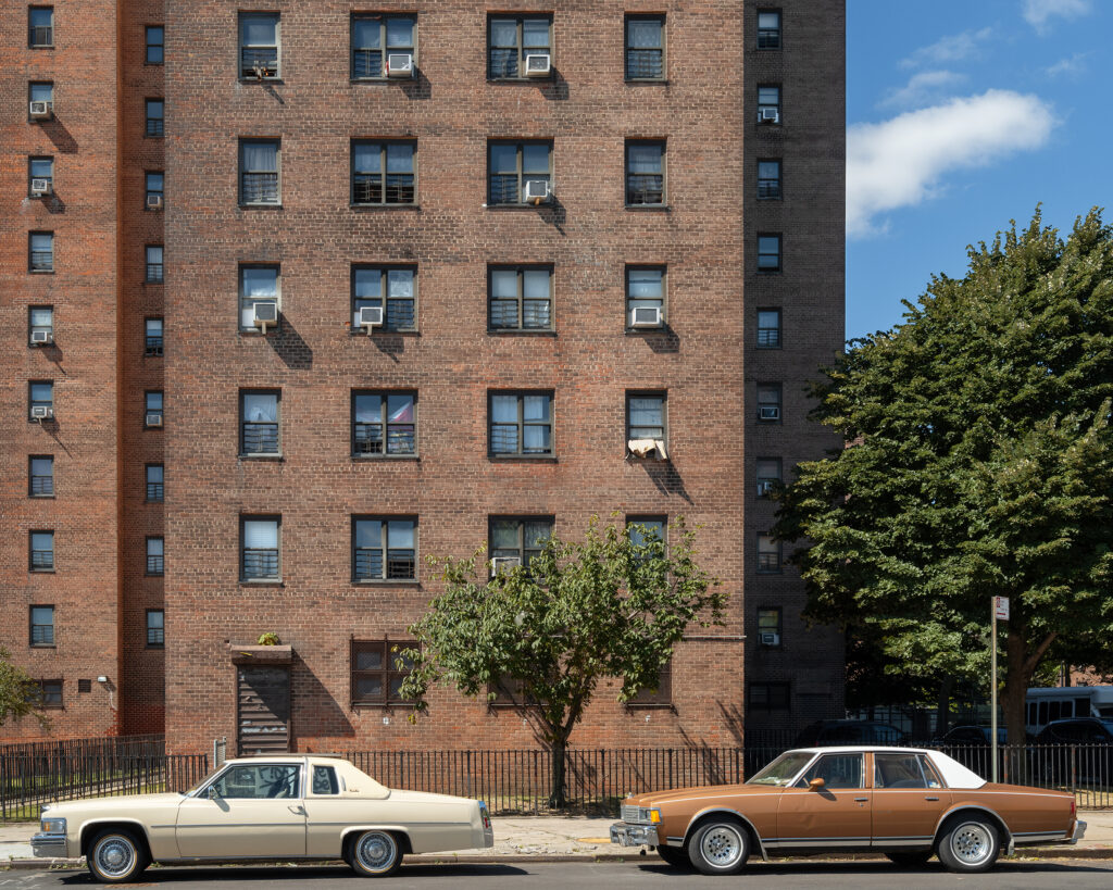 Two cars parked outside a building in Harlem