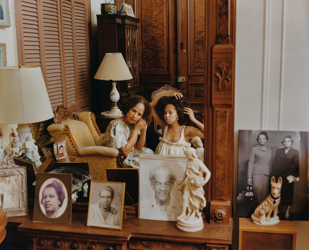 tyler-mitchell-ancestors-2021 Two black women—one older, one younger—look into a mirror together.