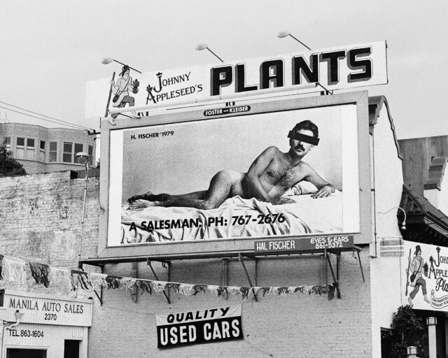 A billboard featuring a nude man reclining on a bed.