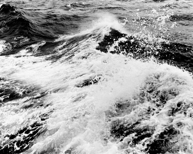 A black and white photograph of ocean waves