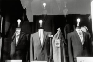 Headless suit mannequins with light bulbs for heads in a NYC store window, 1959.