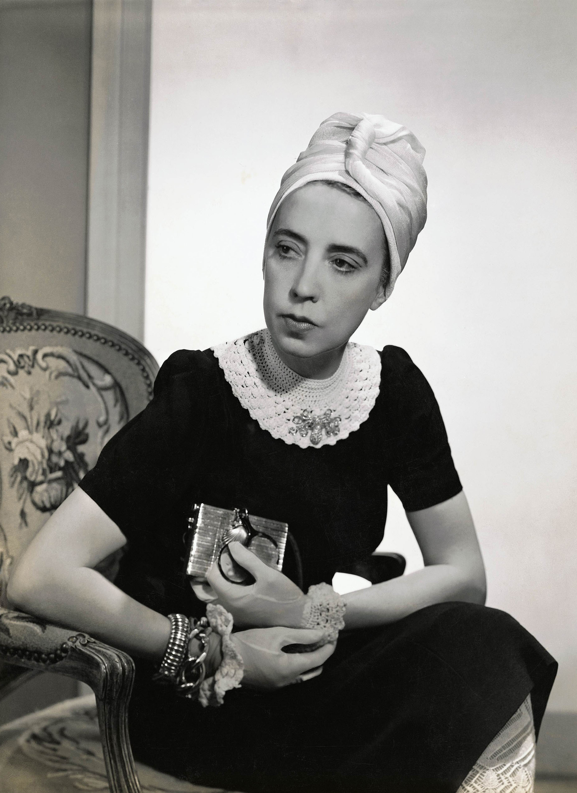 Fredrich Baker, Elsa Schiaparelli wearing black silk dress with crocheted collar of her own design and a turban, <em>Vogue</em>, 1940<br>Courtesy Condé Nast via Getty Images”>
		</div>
		<div class=